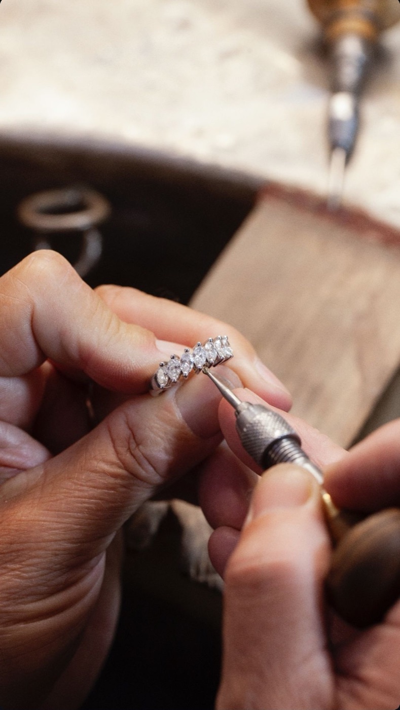 A finished platinum solitaire engagement ring being polished to a mirror finish